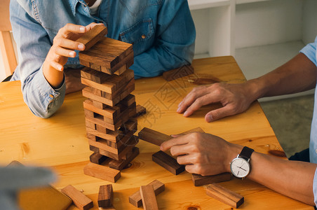 朋友小组在桌上玩木板游戏折叠拼图木板游戏规划商业风险和战略木制的高清图片素材