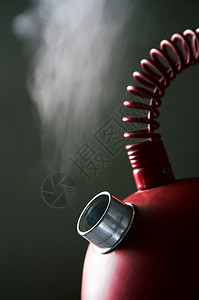 黑暗背景的红沸腾茶壶高清图片
