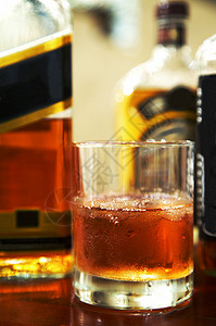 一杯威士忌加冰和酒吧的瓶子高清图片