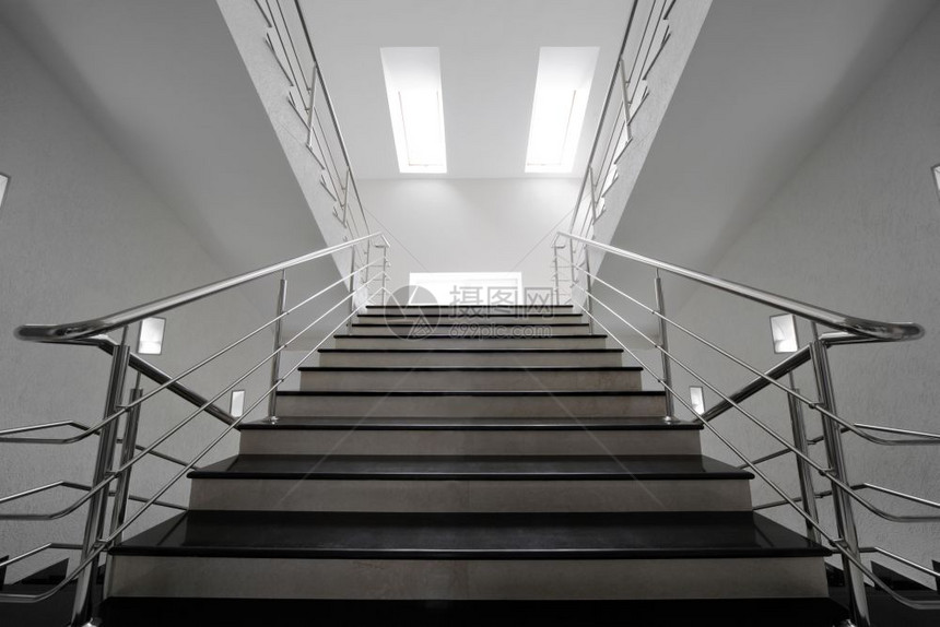 现代建筑中装有钢铁扶手的大理石楼梯图片