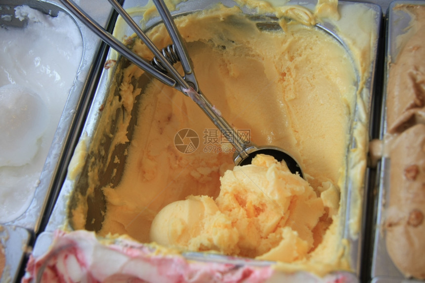 拿勺子准备取出奶黄色的冰淇淋图片