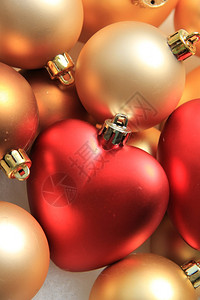 大红心装饰品在一堆金色的圣诞装饰品上图片