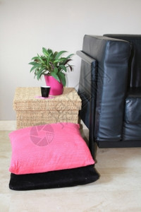 内部设计黑皮沙发水脚凳和粉色枕头图片