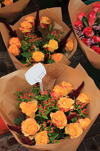 在市场中用纸包成的玫瑰花束图片