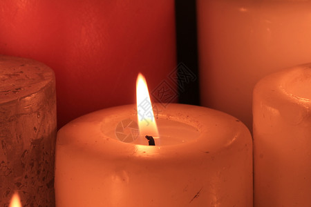 关闭一个燃烧的蜡烛象牙颜色背景图片