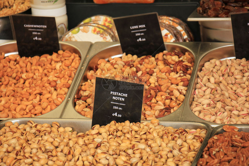市场摊位上的新坚果关于标签的文字荷兰各种坚果的名称和价格皮斯塔乔坚果以及花生和腰的混合图片