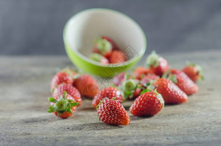 绿色碗盛满新鲜成熟的红草莓图片