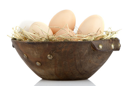 白色反射背景木碗上的鸡蛋图片