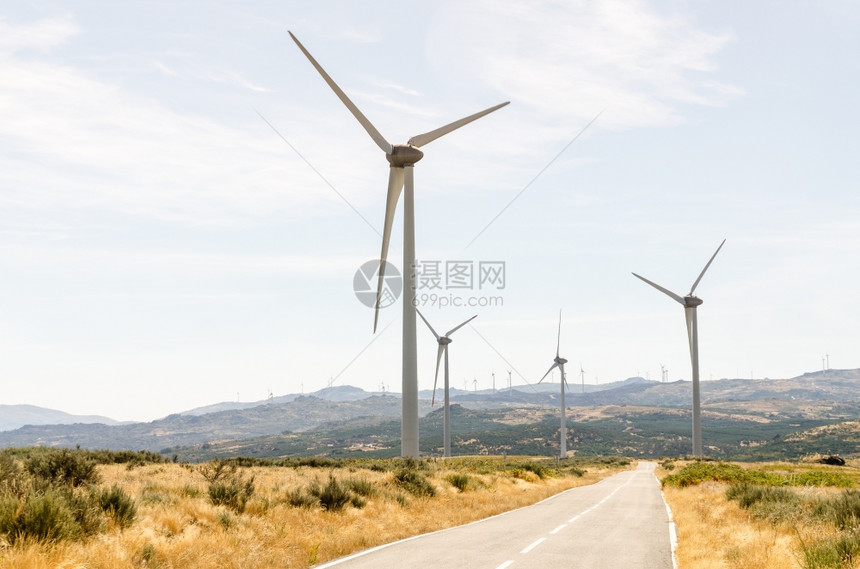 穿越风力涡轮机山地的平面公路图片