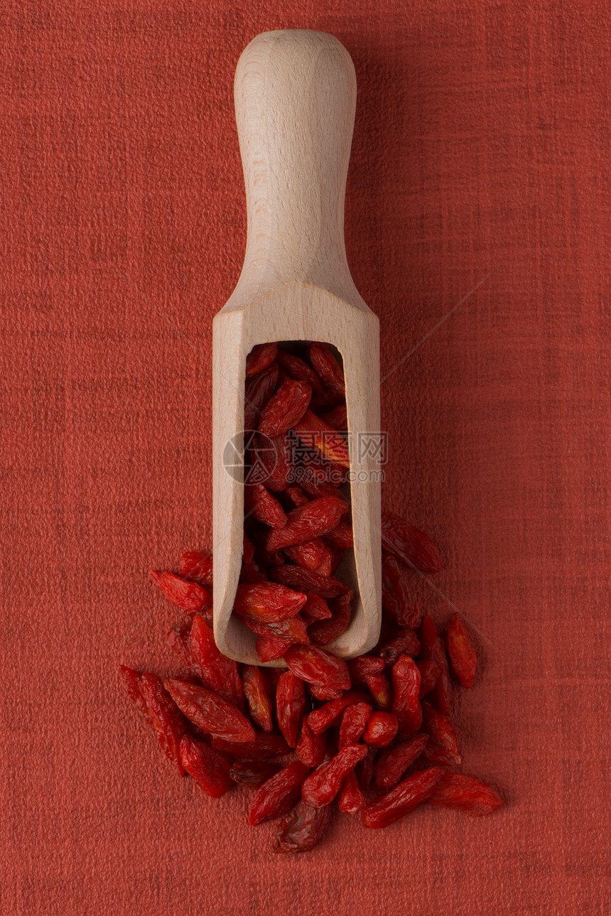红色黑莓背景的木制勺子顶端视图图片