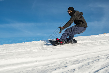 在山上骑着滑雪车与蓝天对峙图片