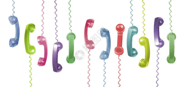 许多不同颜色的旧电话听筒挂在白色背景上图片