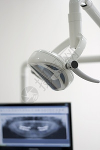 在牙医门诊室用电灯和从病人嘴部抽取的腹腔X光检查设备图片