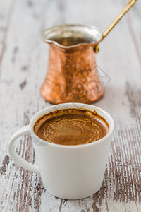 土耳其白色木制背景的土耳其咖啡和壶图片