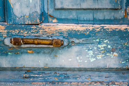 传统的旧木制蓝色门的黄把手图片