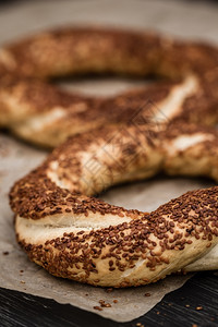 Simit精美烘烤传统土耳其面包圈棕纸上含芝麻的图片
