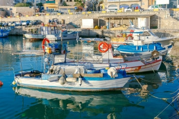 阳光明媚的清晨在希拉克利翁旧港捕捞多色渔船希腊克里特拉克利昂旧港渔船背景图片