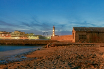 古老港口的景色闪耀着希臘克里特的Chania灯塔图片