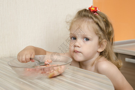 小女孩坐在厨房里喝粥图片