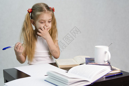 女孩坐着思考写作业图片