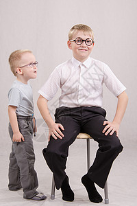12岁男孩戴眼镜坐在椅子上站一个男孩旁边图片