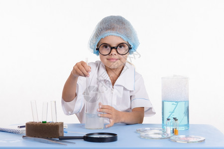 女孩坐在桌上做化学课的试剂和实验图片