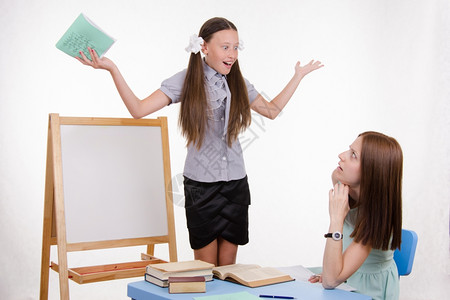 学生站在黑板上老师坐在书桌旁听学生讲话图片