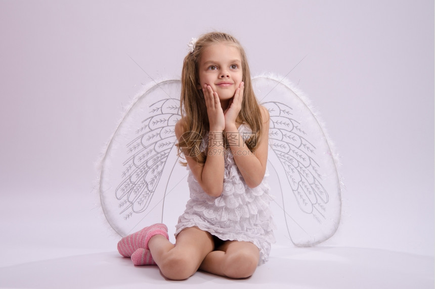 6岁女孩穿着明亮的天使服装白色背景上有翅膀图片