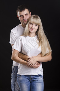 一个年轻情侣的半长肖像男人抱着一个女孩回来工作室黑人背景图片