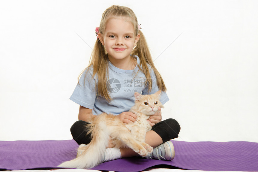 坐在地毯上抚摸猫腿的快乐女孩与家猫一起坐在地毯上运动后六岁的欧洲女孩与家猫一起在地毯上运动了六岁欧洲女孩图片