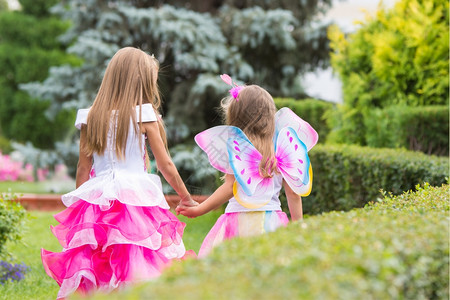 仙女花园快乐的小女孩穿着粉红裙子在花园里拍照背景