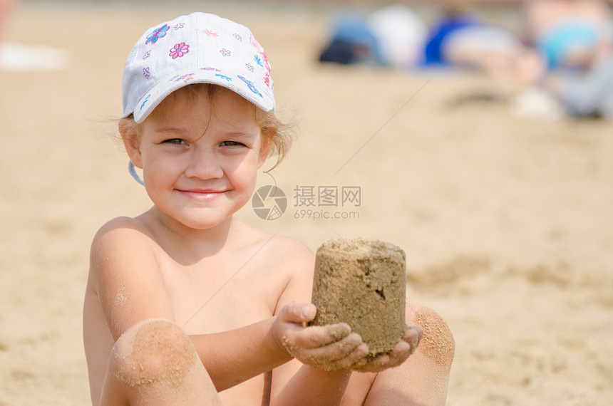 女孩坐在河岸沙滩上坐在图片