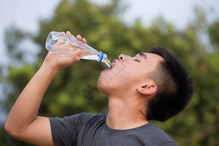 男青年或少用塑料瓶喝的饮水背景图片