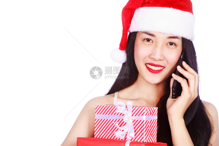穿着圣诞老人服装的女打电话带礼物盒孤立在白色背景图片