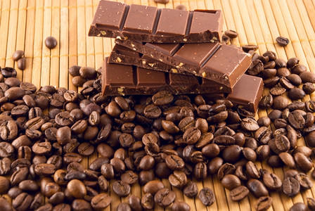 竹垫上巧克力和咖啡豆图片