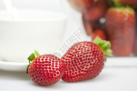 多汁的草莓和白色孤立杯子图片