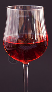 黑色背景的玻璃杯葡萄酒图片