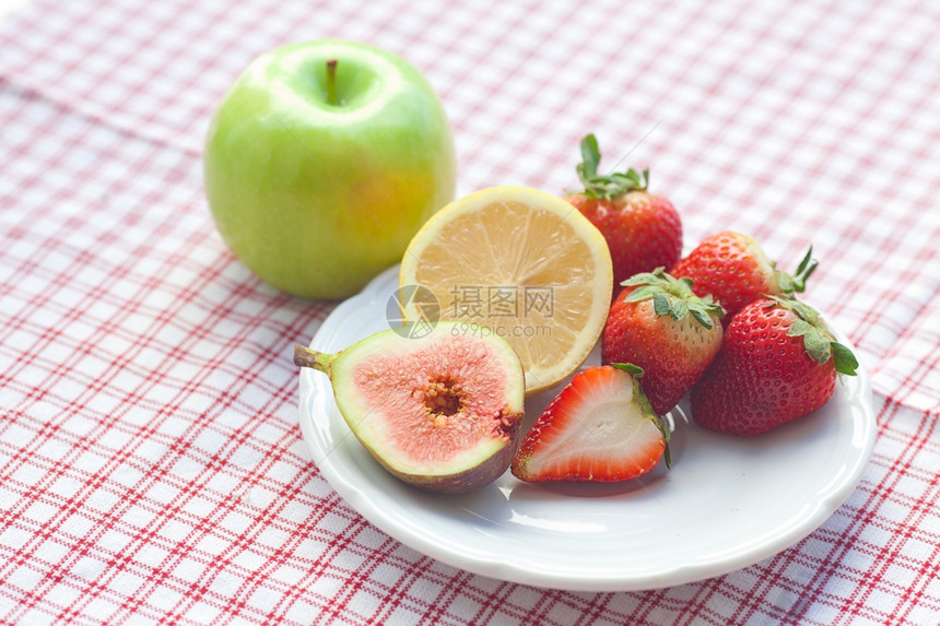 盘子上的苹果柠檬无花和草莓图片