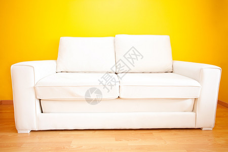 白沙发对着公寓的黄色墙壁图片