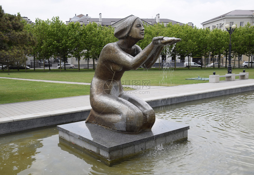 女人跪在泉中水流雕像的手下跪女子水泉中手图片