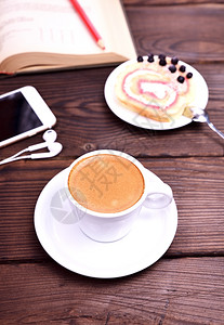 咖啡杯和棕色桌上的手机关门图片