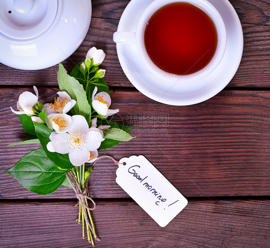 一杯茶个碟子和束白花的茉莉顶端的景色图片