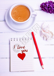 一杯咖啡和张纸笔记本上面写着我爱你的字背景图片