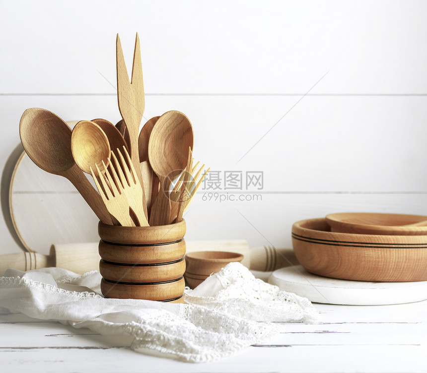 木制罐勺子叉滚动针板和白木制桌上的筛子图片