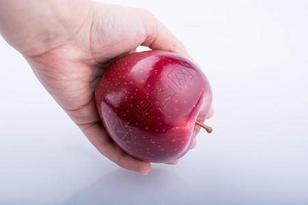 手持美丽的红苹果白色背景背景图片