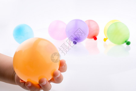 手握着一个多彩小气球白底带多彩的子图片