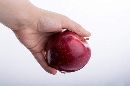 手持美丽的红苹果白色背景背景图片