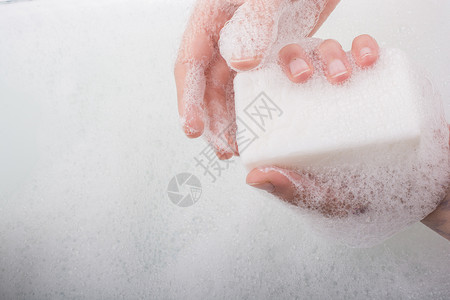 儿童用肥皂洗手和在泡沫背景下的肥皂泡沫图片