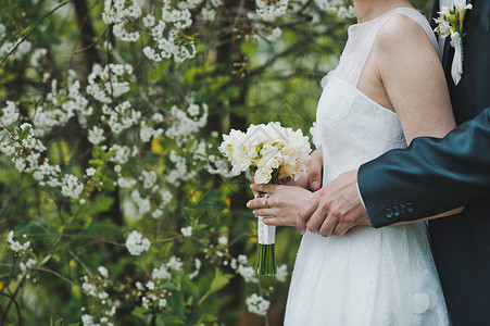 美丽的婚礼花束放在新婚夫妇手上礼背景图片