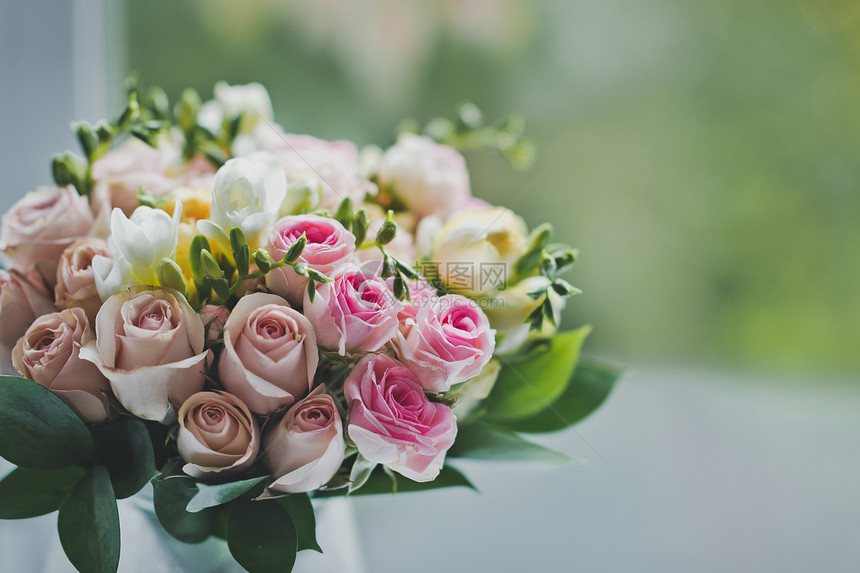 桌子上有一束小玫瑰花放在一壶水里婚礼花朵正等待着675年的时间婚礼花束正在等待着675年的时间婚礼花束正在等待着675年的时间图片